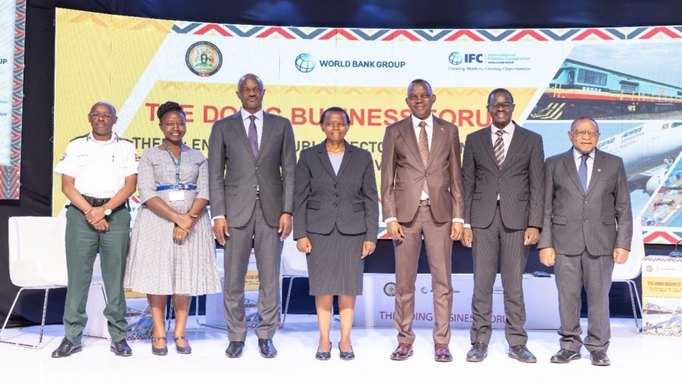 Speakers and officials standing together on stage in front of an earlier Doing Business Forum's backdrop. Not a photograph of this edition.
