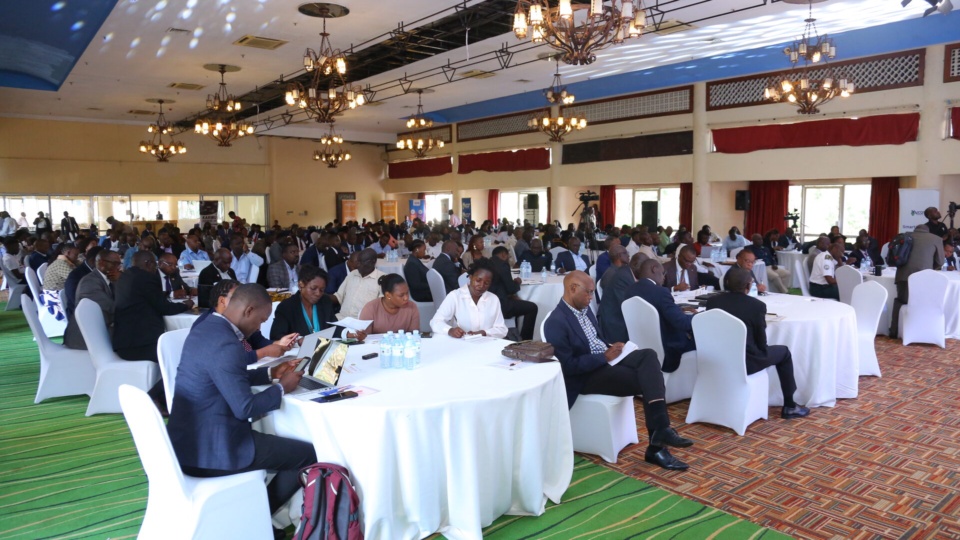 A hall of delegates seated at round tables during the Forum.